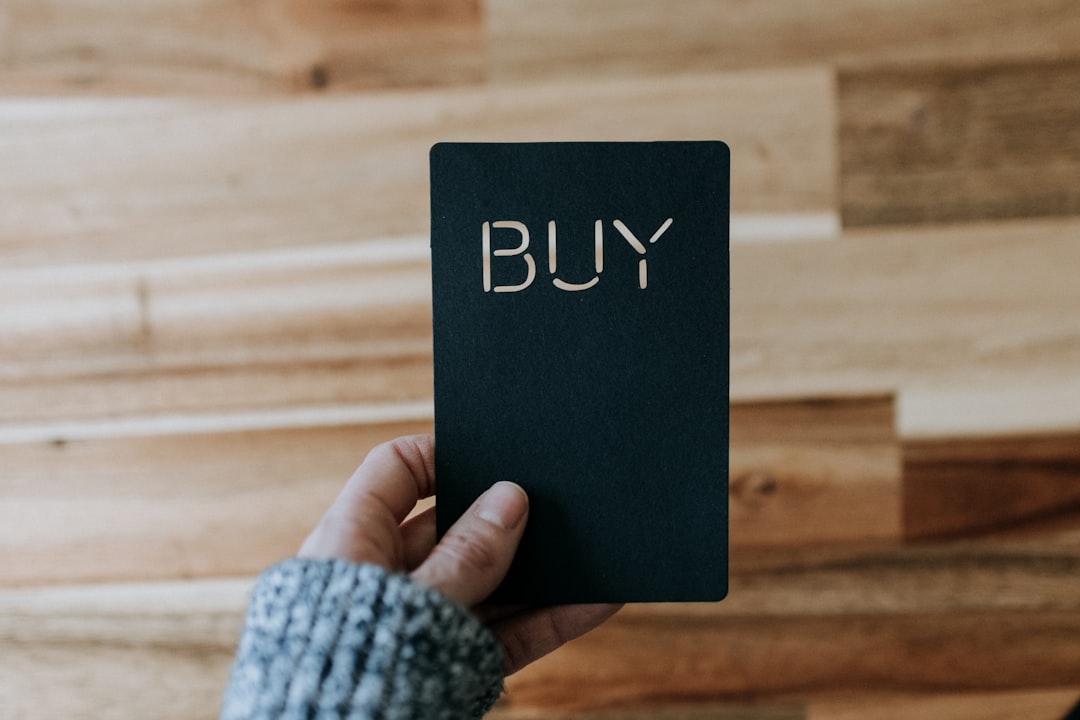 A person holding a black book with the word 