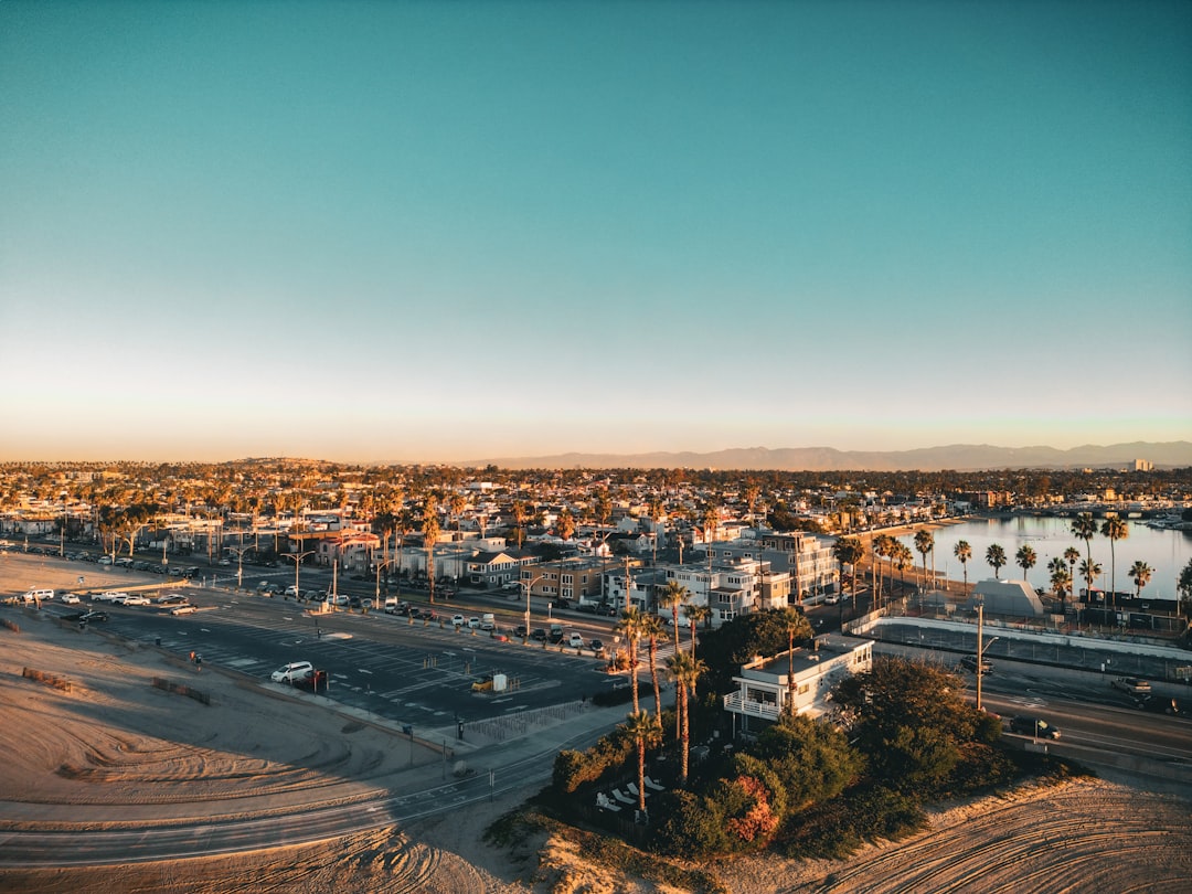 Aerial view of a picturesque coastal town featuring lush palm trees and a serene ocean backdrop, ideal for first-time home buyers seeking a tranquil seaside lifestyle in 2026.