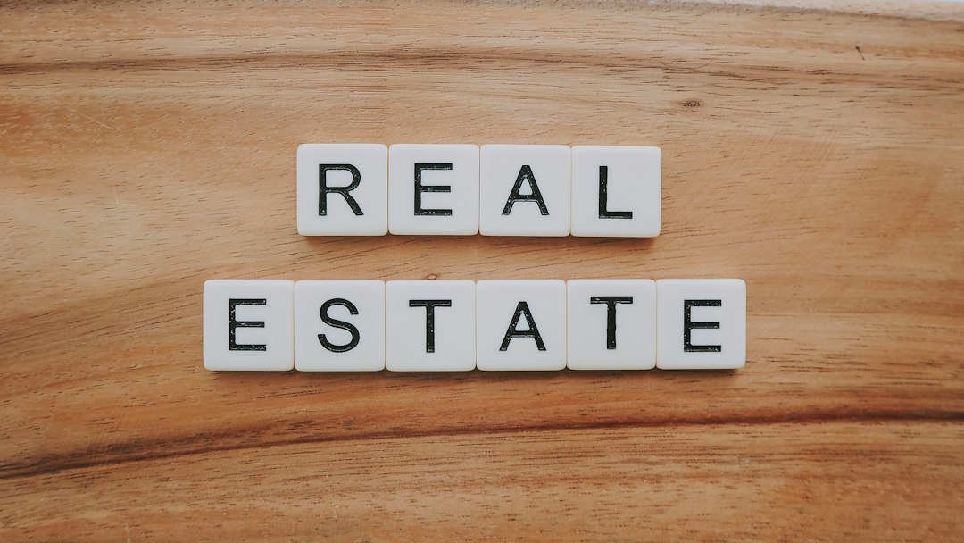 Letter tiles spelling “REAL ESTATE” on a wooden surface.